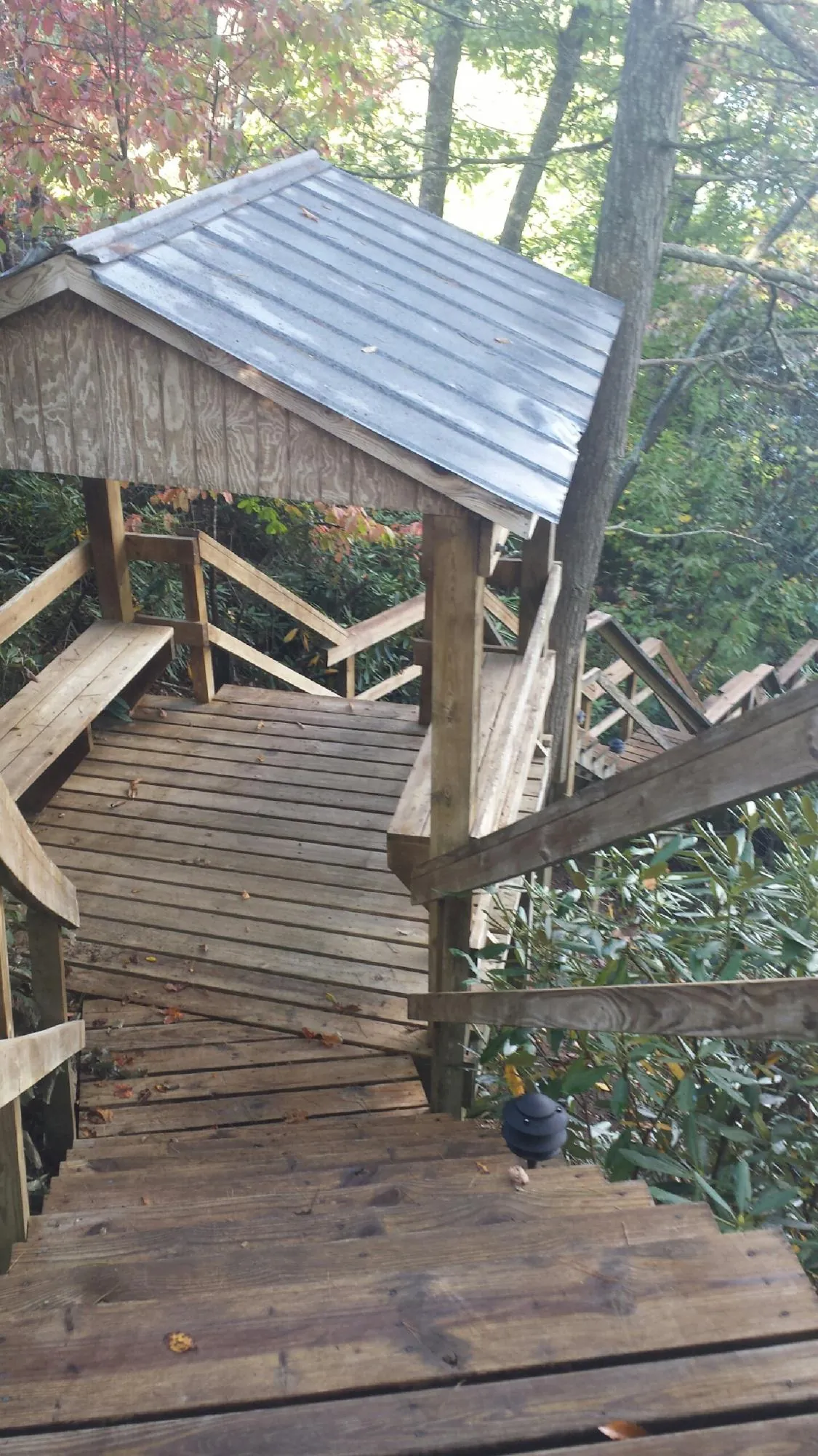 Metal roofed shelter over wooden steps on a wooded walkway — Skylight Repair & Installation work by our crew in Cranston