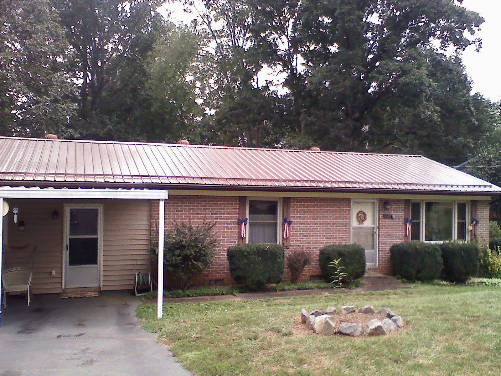 Bronze metal roof and carport on a brick ranch home — Roof Repair work by our crew in Cranston