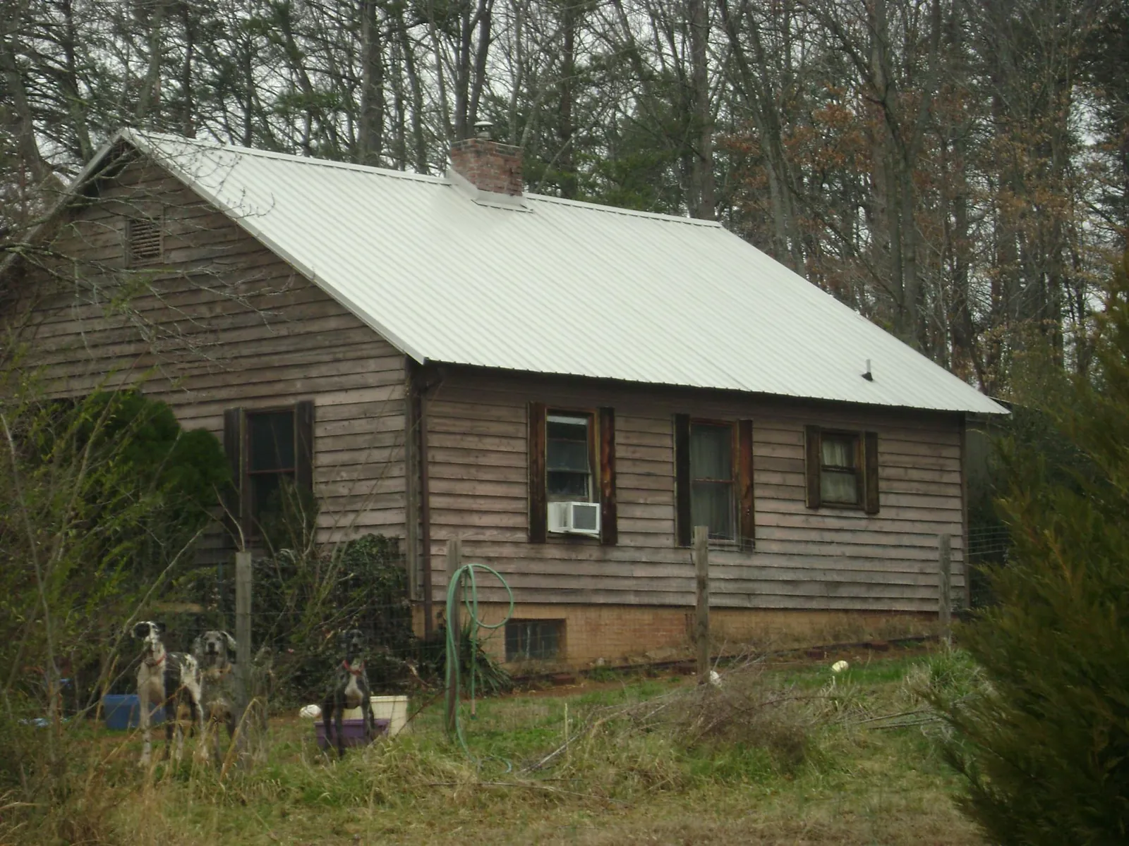 White metal roof on an old wood sided farmhouse, from a Metal Roof Installation job in Cranston